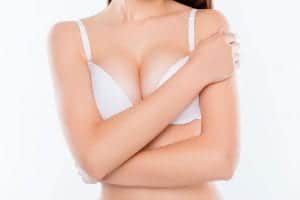 Woman covering her self in a white bra.